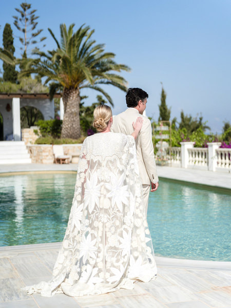 Bride and groom first look by infinity pool at Petra Farm wedding in Paros Greece.