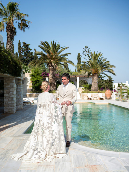 Bride and groom first look by infinity pool at Petra Farm wedding in Paros Greece.