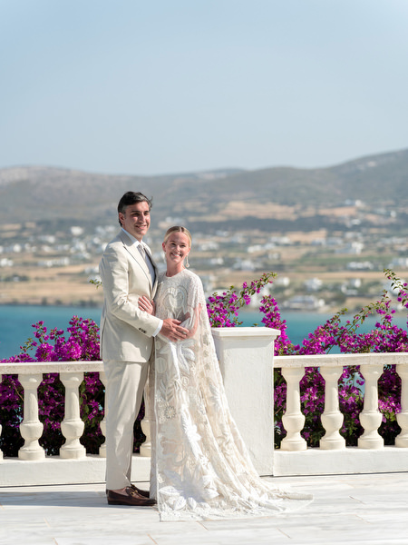 Bride and groom posing on terrace with bougainvillea at Petra Farm Paros.
