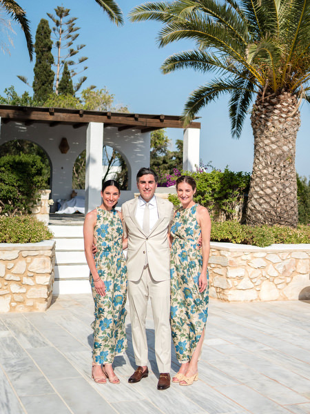 Groom with bridesmaids in blue floral dresses at Paros destination wedding venue.