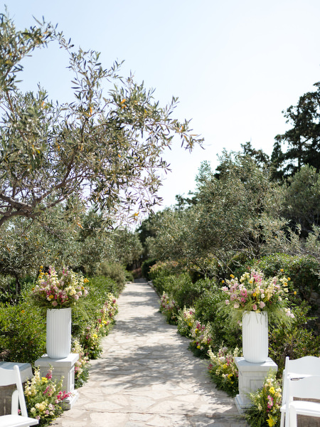 Garden pathway decorated with florals leading to Petra Farm chapel ceremony in Paros.