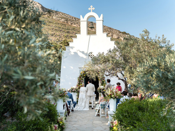 Outdoor Orthodox ceremony at Petra Farm chapel surrounded by olive trees in Paros.