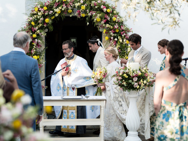 Bride and groom wearing Orthodox wedding crowns at Paros Greek island ceremony.