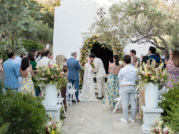 Bride and groom kissing at Paros Greek island ceremony.