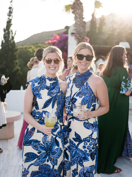 Guests in blue floral dresses at Petra Farm Paros cocktail reception.