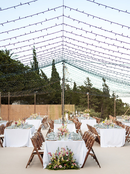 Outdoor wedding reception under string lights at Petra Farm Paros Greece.