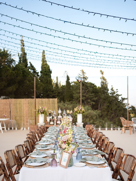 Long wedding dinner table under fairy lights at Petra Farm Paros Greece.