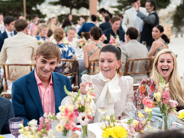 Wedding guests laughing during outdoor dinner at Petra Farm Paros.