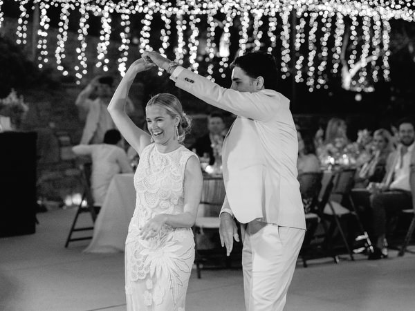 Bride and groom dancing under fairy lights at Petra Farm Paros wedding.