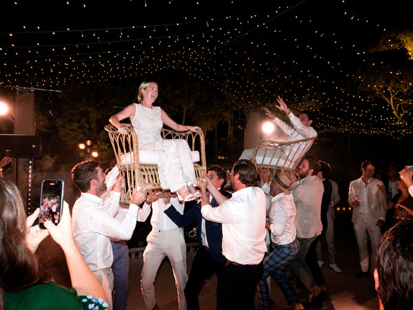 Bride and Groom lifted by friends during Paros island wedding reception.