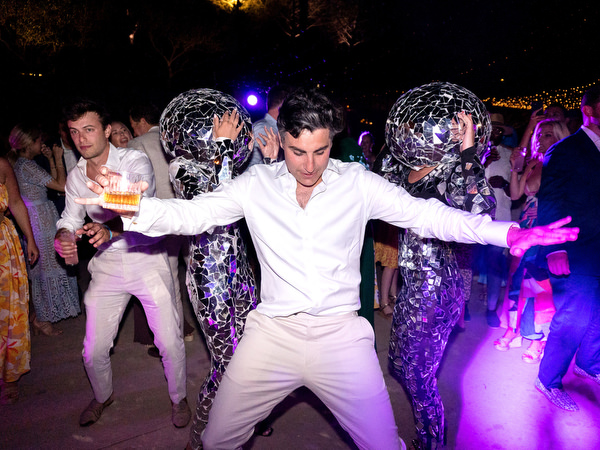 Wedding entertainers dancing with groom at Petra Farm Paros luxury reception.