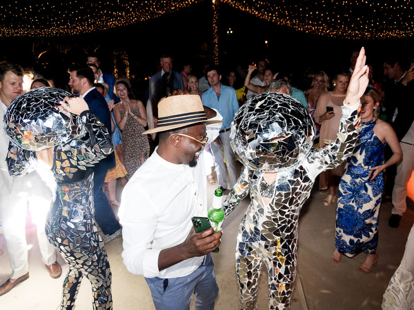 Guests dancing under string lights at Petra Farm Paros wedding party at night.