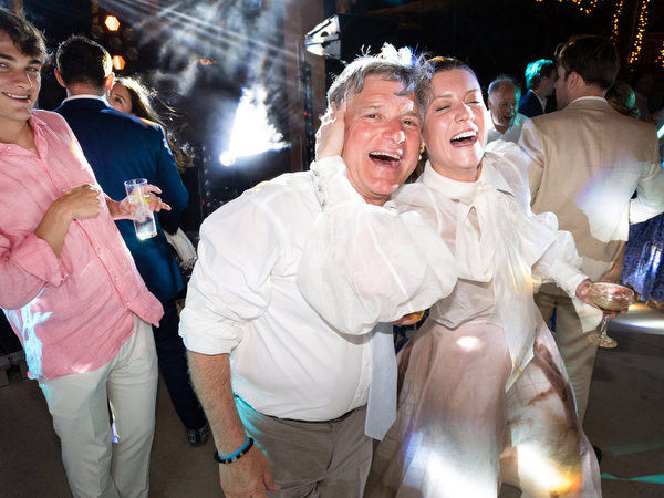 Guests laughing during late-night Paros wedding celebration.