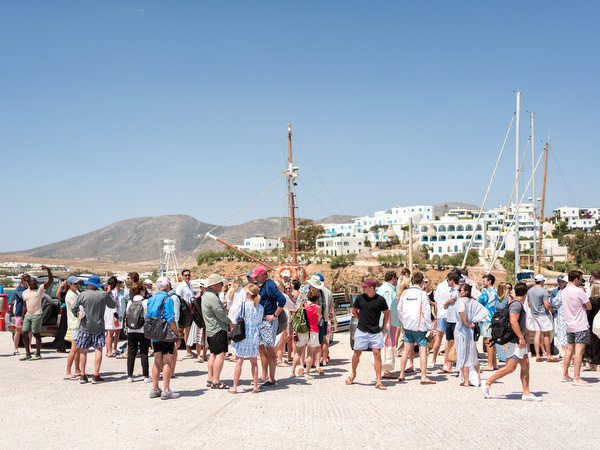 Large group of wedding guests preparing to sail from Paros harbor