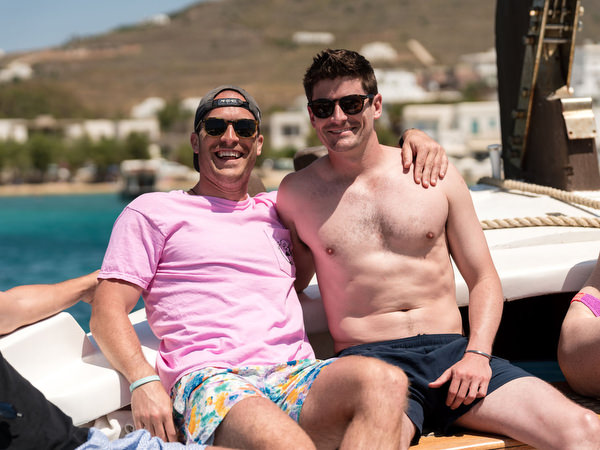 Wedding guests enjoying views of Paros coastline during boat trip