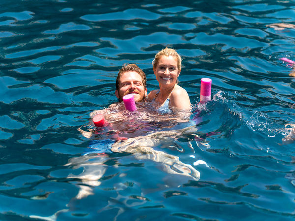 Couple swimming in turquoise water during Paros wedding cruise