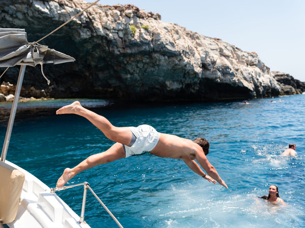 Guest diving from boat during Greek island sailing celebration
