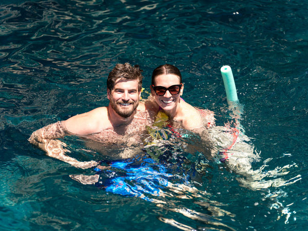 Friends celebrating with drinks in the water during sailing day