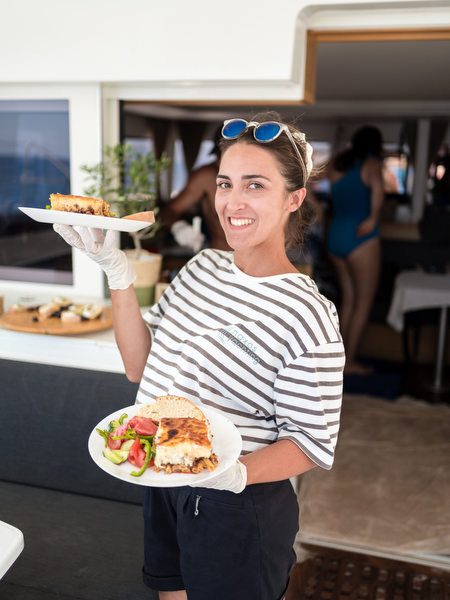 Guest serving food on sailing boat during Paros celebration
