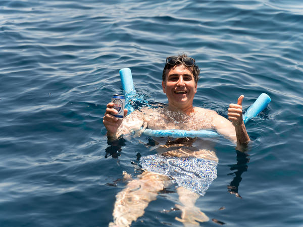 Guest floating in the sea with snorkeling gear during boat trip
