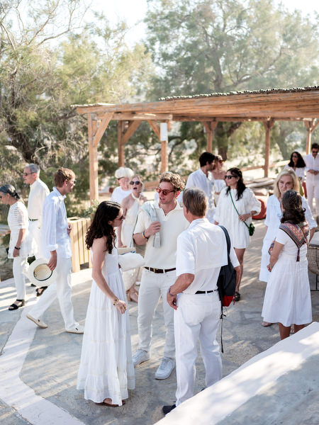 Wedding guests mingling at Monastiri Beach celebration in Paros
