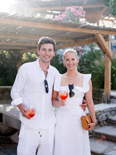 Couple in white with aperol cocktails at Greek island wedding welcome party