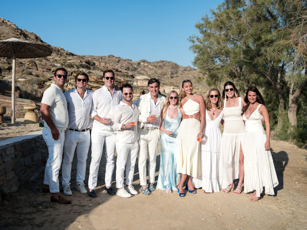 Wedding guests posing with couple along Monastiri Beach venue