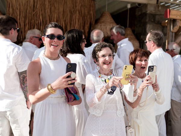 Wedding guests taking candid photos during Paros welcome party