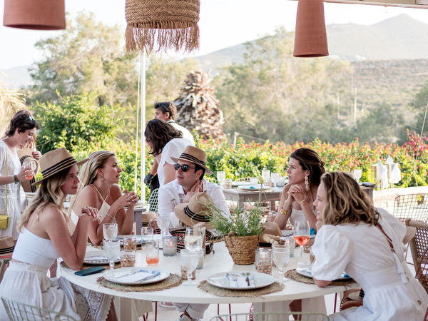 Wedding guests seated at long table during Paros celebration
