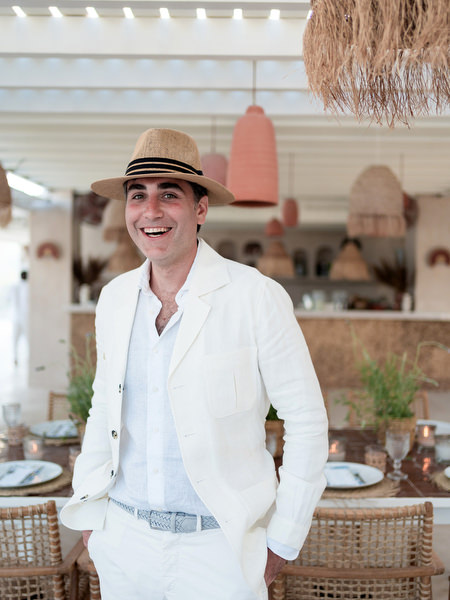 Groom wearing straw hat during Paros wedding celebration