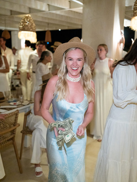 Bride holding money on dance floor during Greek wedding tradition