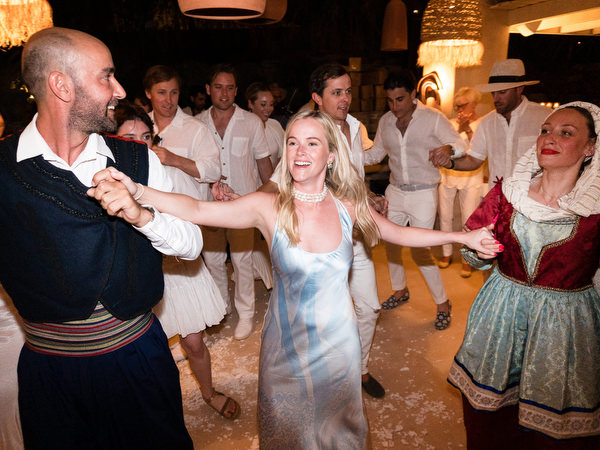 Bride dancing with traditional dancers during Paros wedding party