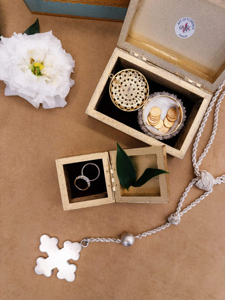 Wedding rings, cross necklace, and bridal accessories styled for elegant Athens church wedding.