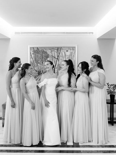 Bridesmaids in matching dresses posing with bride before Athens Catholic church wedding.