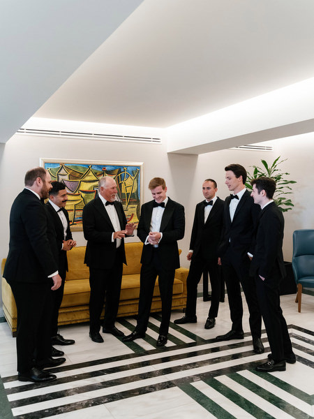 Groom with family and groomsmen during preparation for Catholic wedding in Athens Greece.