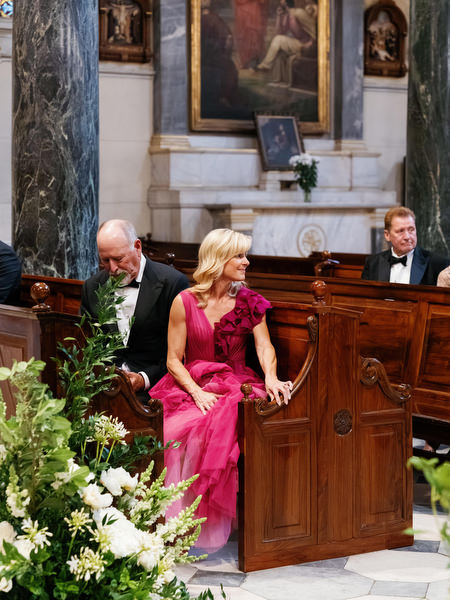 Guests seated inside ornate Catholic church in Athens during elegant luxury wedding ceremony.