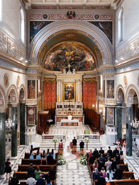Wide view of ornate Catholic cathedral interior in Athens during luxury destination wedding ceremony.