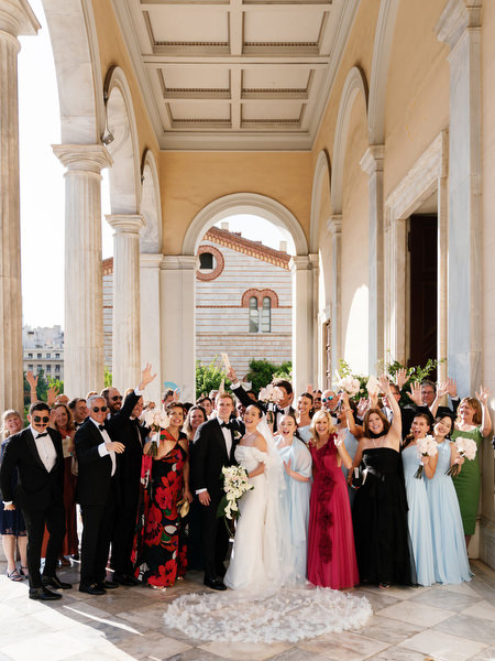 Wedding guests gathered outside Athens cathedral celebrating luxury Catholic destination wedding.