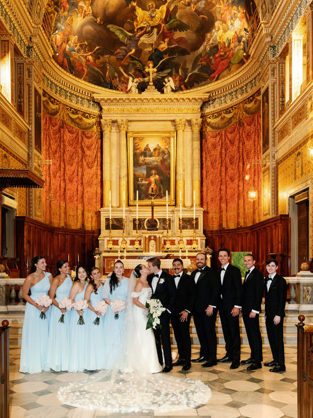 Bridal party posing at altar inside ornate Catholic cathedral before Island Resort Athens reception.