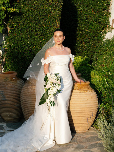 Bride holding bouquet posing at The Residence Island Resort Athens during golden hour wedding portraits.