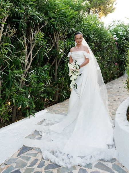 Bride posing in off-shoulder gown along garden pathway at The Residence Island Resort Athens.