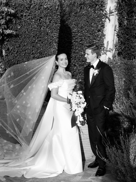 Bride and groom walking with flowing veil during sunset portraits at Athens Riviera wedding.