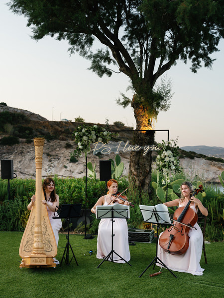 String trio performing during cocktail hour at luxury Island Resort Athens Riviera wedding.
