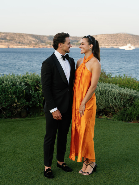 Wedding guests posing at sunset during cocktail hour at The Residence Athens Riviera.