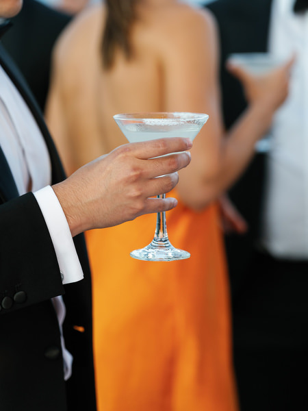 Close-up of cocktail held during sunset reception at luxury Athens Riviera wedding venue.