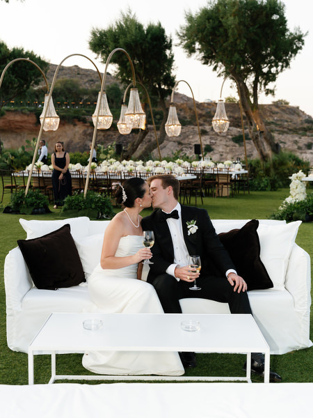 Bride and groom seated together at reception lounge during Athens Riviera wedding celebration.