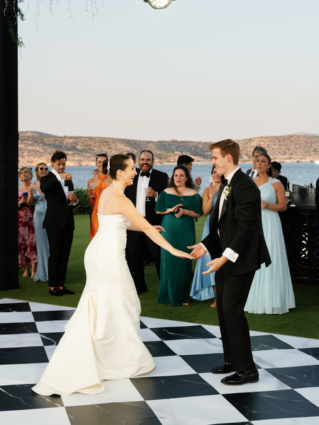 Bride and groom beginning first dance on black and white dance floor at Athens Riviera wedding.
