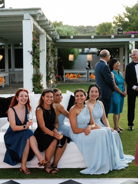 Bridesmaids and guests seated together at outdoor reception at Island Resort Athens Riviera.