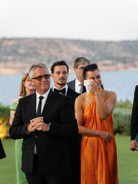Wedding guests visibly emotional during outdoor reception speeches at Island Resort Athens Riviera.
