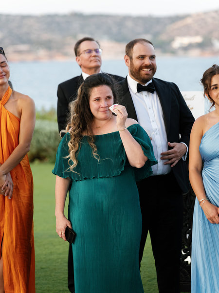 Guest wiping tears during emotional speech at luxury Athens Riviera wedding reception.